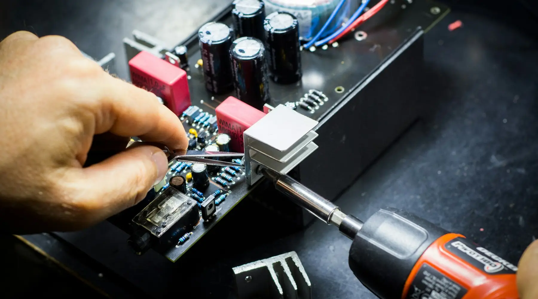 A hand soldering components onto a circuit board
